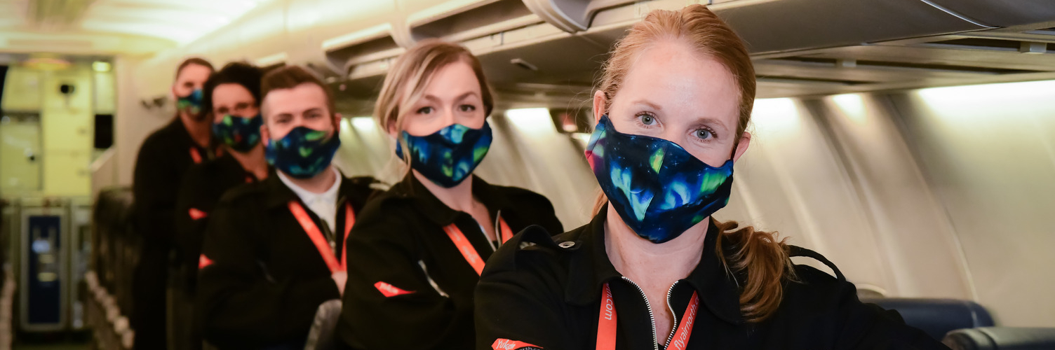 Air North flight attendants wearing cloth masks onboard an aircraft