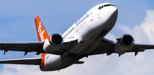An Air North plane in a blue sky with clouds