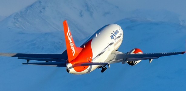 An Air North plane flying over beautiful mountains