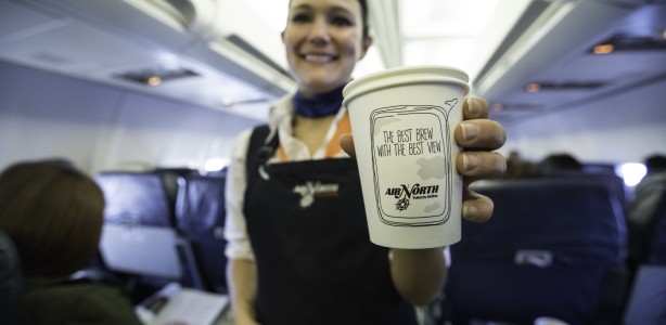 Air North employee holding a cup of coffee