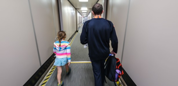 An Air North passenger services agent accompanies an unaccompanied minor on a jetbridge.
