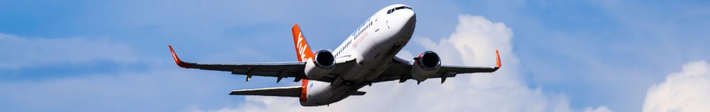 An Air North plane in a blue sky with clouds