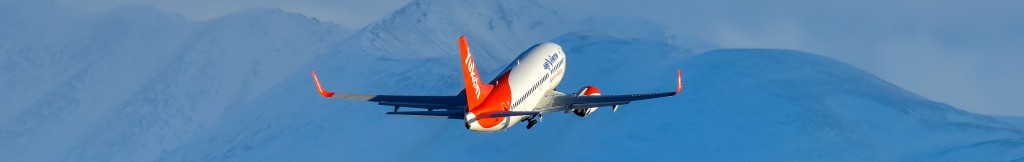 An Air North plane flying over beautiful mountains